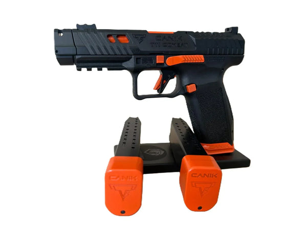 Canik TTI Custom Sportpistole mit orangenen Akzenten und zwei Magazinen auf Ständer