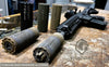 Q-WORKS Schalldämpfer und taktisches Gewehr auf Holztisch, Stonehawk Logo im Vordergrund